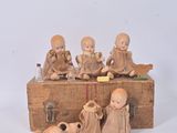 figurines représentant un groupe d'enfants assis sur une caisse en bois