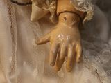 a close up of a doll ' s hands on a cloth