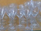 many empty wine glasses on a shelf in a store