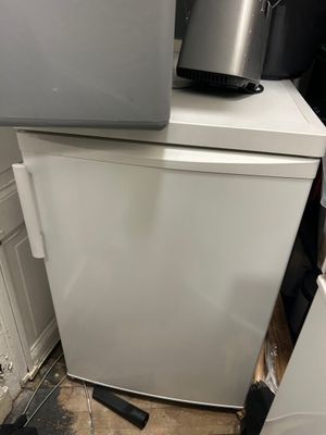 a white refrigerator and a silver refrigerator freezer next to each other
