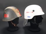 pair of helmets on display on a black surface with a dark background