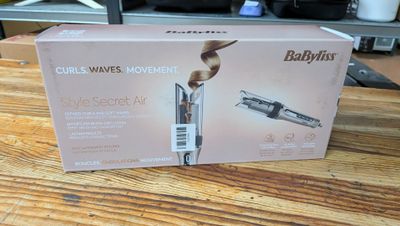 emballage d'un fer à friser Babyliss posé sur une table en bois dans une cuisine