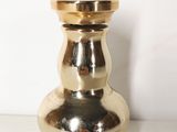 un vase doré posé sur une table blanche