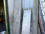 plusieurs morceaux de métal sont empilés à l'extérieur d'un bâtiment