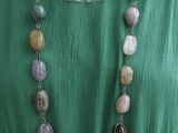 une femme portant une robe verte et un collier composé de perles multicolores