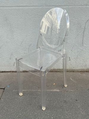 une chaise en plastique transparent posée au bord de la rue