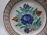 a plate with a blue flower on it on a table