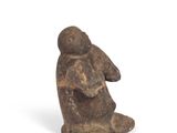 an image of a statue of a person sitting on a white surface