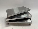 three metal trays stacked on top of each other on a table