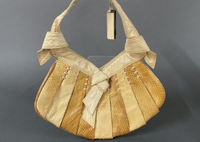 a beige purse with a bow on top of it