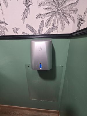 des toilettes avec un distributeur de papier dans un coin de la salle de bains