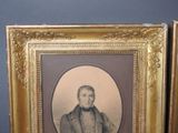 an old picture of a man in a suit and tie in a gold frame