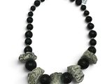 un gros plan sur un collier composé de perles noires et blanches