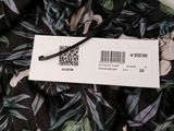 a close up of a black and green floral dress with a price tag on it