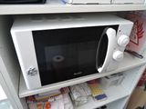 a microwave that is sitting on a shelf in the kitchen