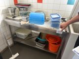 a man that is standing in a kitchen with a mop and buckets