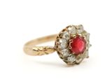 gros plan d'une bague en or avec une pierre rouge