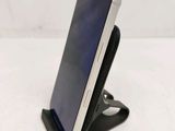 a close up of a cell phone on a stand on a table