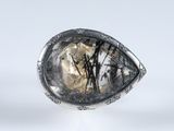 un gros plan d'une bague en argent sertie d'un quartz facetté