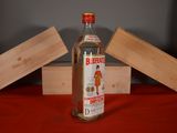 a bottle of alcohol sitting on a table next to a box