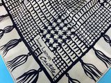 a close up of a black and white scarf on a blue surface