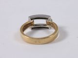 a close up of a gold and silver ring on a white surface