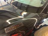 a close up of a shiny black car with a sticker on it ' s hood