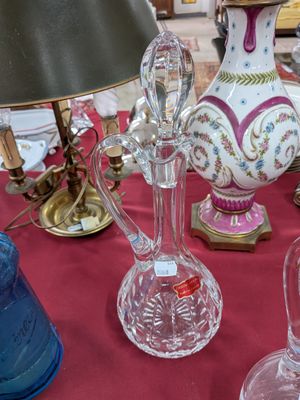 de nombreux vases en verre posés sur une table sur laquelle se trouve une lampe