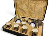 a case that has a set of cups and saucers in it
