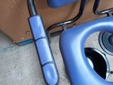 a blue toilet seat with a blue handle next to a brown box