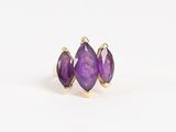 un gros plan sur une paire de boucles d'oreilles en pierre violette posées sur une surface blanche