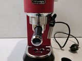a red espressor machine sitting on a white table