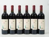 six bouteilles de vin rouge sont alignées sur une surface blanche