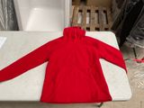 un sweat-shirt rouge posé sur une table dans une pièce