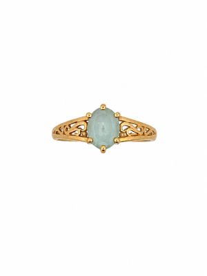 a close up of a gold ring with a green stone