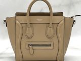 a beige leather handbag with zippers and handles on a white background