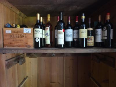 Des bouteilles de vin sont alignées sur une étagère dans un meuble en bois