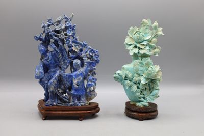 une paire de vases bleus et verts posés sur un socle en bois, sur fond gris