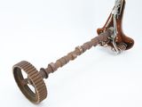a metal object with a wooden handle on a white surface