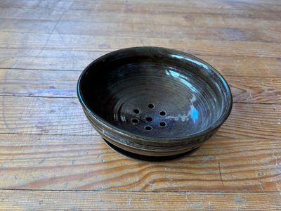 un bol noir posé sur une table en bois