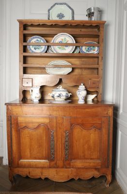 a wooden cabinet with many plates on top of it