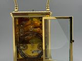 a gold clock with a glass case on top of it