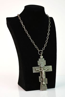 un gros plan d'un collier orné d'une croix, porté par un mannequin