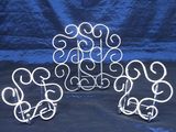 trois sculptures métalliques aux formes tourbillonnantes reposent sur une surface bleue
