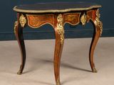 a small table with a black top and gold decorations