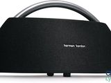 a black speaker sitting on top of a table next to a white wall