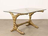 a table with a glass top and gold metal legs