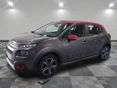 Une Citroën grise et rouge est garée dans un garage
