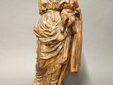 wooden statue of a woman holding a baby and a dog