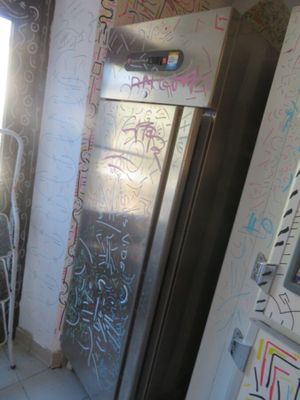 une salle de bains avec des graffitis sur les murs et des toilettes